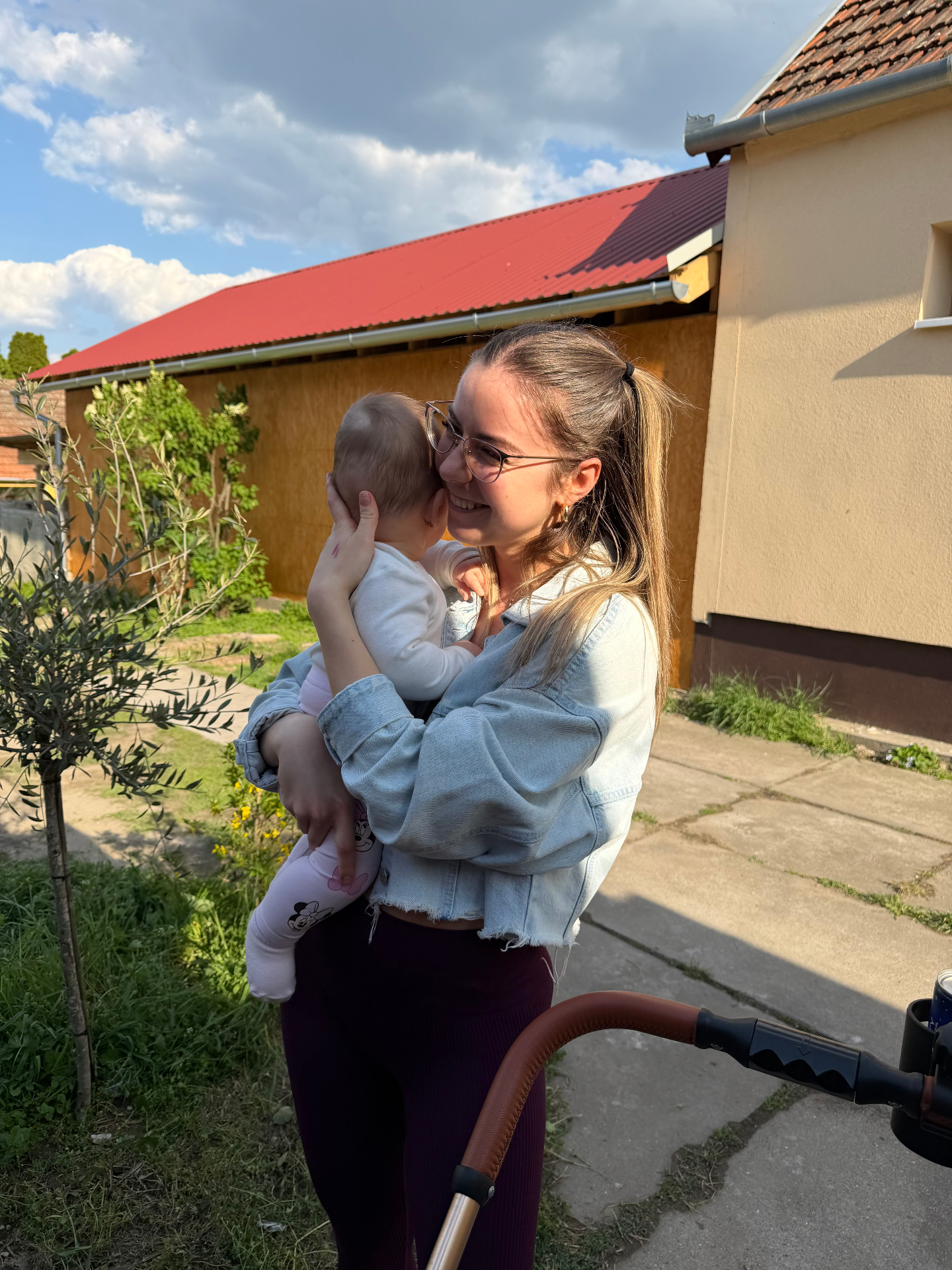 Lizett ölelget egy kisbabát a napsütésben